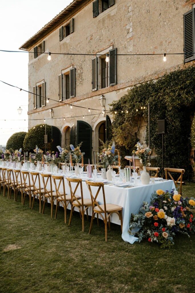 LAnge diner tafel vol met bruiloft decoratie en een prachtig bloemstuk op de grond