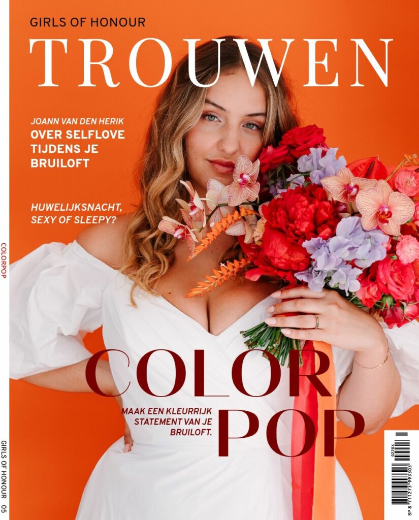 De cover van TROUWEN magazine met een oranje achtergrond en een wit model in een witte trouwjurk. Ze heeft een kleurrijk boeket vast en lang blond haar.